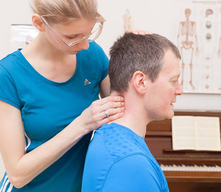 Ariane Hüser behandelt den Nacken eines Patienten