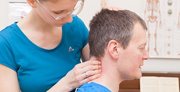 Ariane Hüser behandelt den Nacken eines Patienten - Weiterleitung zur Unterseite Kopf und Nacken-Leistungen